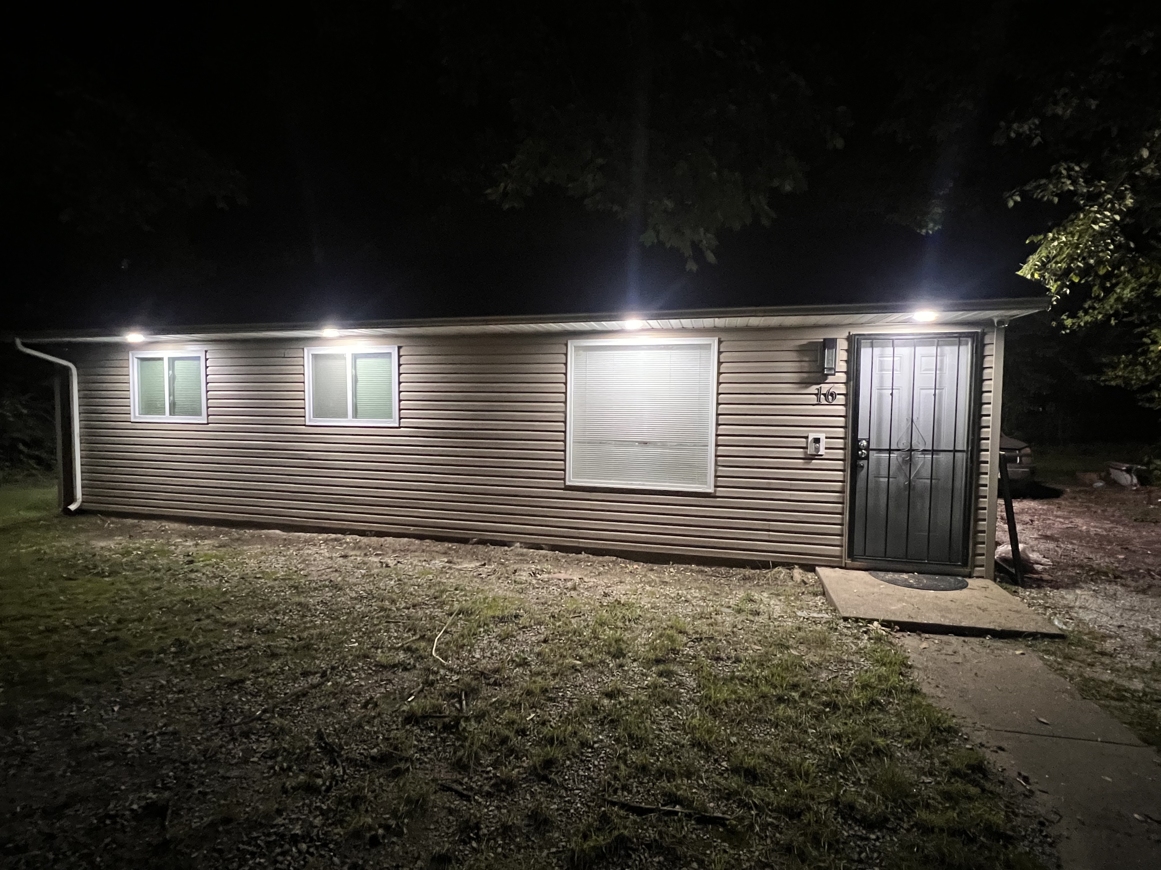Evening view of the home with exterior lights illuminated