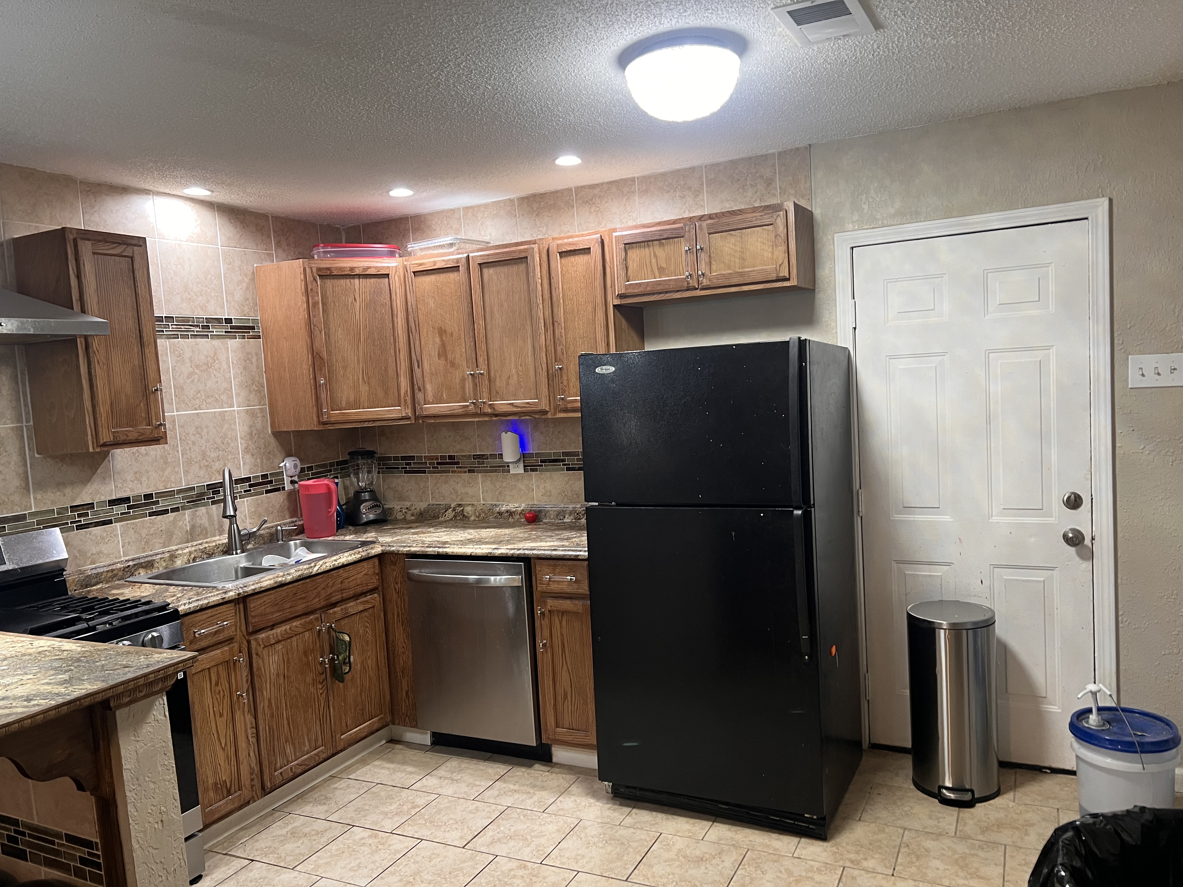 Kitchen with refrigerator, dishwasher, counters and wood cabinets